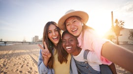 three women pose for a selfie at the beach as they consider why the July 2023 super buck moon will a...