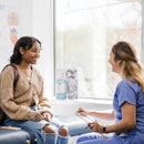 The young adult female patient smiles while listening to the nurse give an encouraging update regard...