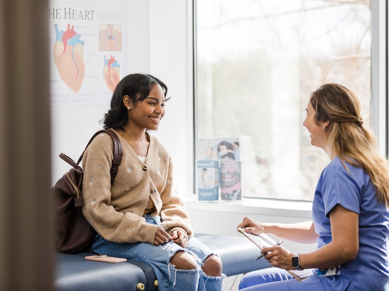 The young adult female patient smiles while listening to the nurse give an encouraging update regard...