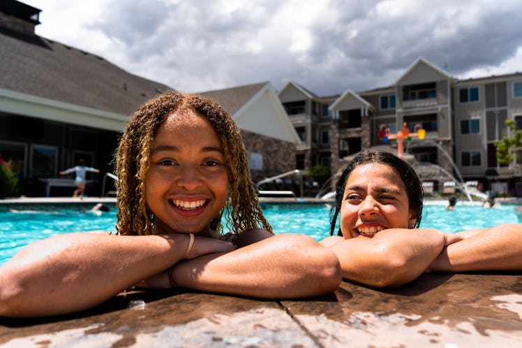 Against the backdrop of a sun-kissed pool, two multi-racial girls, aged 13 to 15, exude joy and frie...
