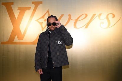 Formula One's British driver Lewis Hamilton poses for a photocall at the Louis Vuitton Menswear Spri...
