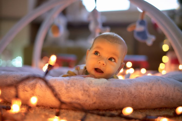 Cute baby girl relaxing on blanket at home.