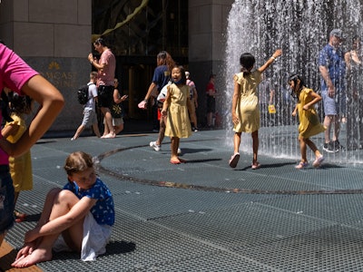 NEW YORK, NEW YORK - JULY 23: Children play in the Changing Spaces fountain by Jeppe Hein at Rockefe...