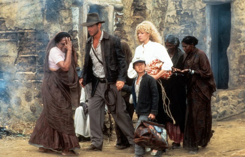Harrison Ford, Jonathan Ke Quan and Kate Capshaw are lead through a temple in a scene from the film ...