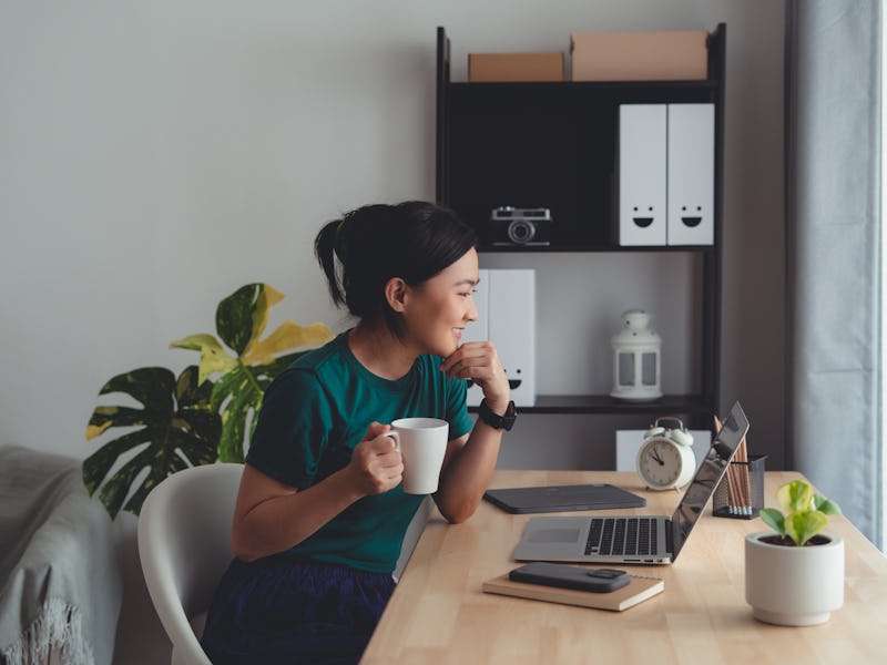 Asian woman chill with relax time take a break drinking warm coffee sitting at home office.
