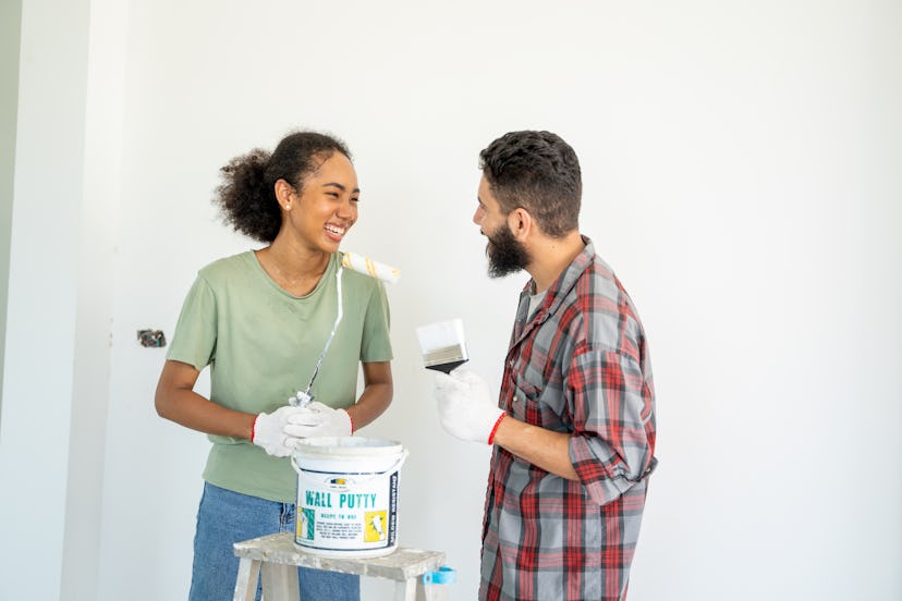 Smiling friends work together to paint to finish the house,Repair together themselves.