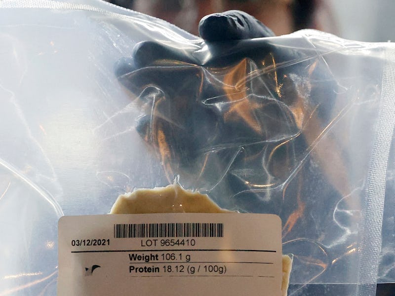 A technician holds a lab-grown chicken meat in a sealed bag at the food-tech startup SuperMeat in th...
