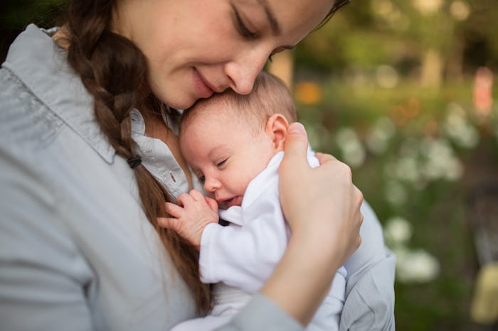 Bird baby names would suit this little baby, cradled against her mom's chest.