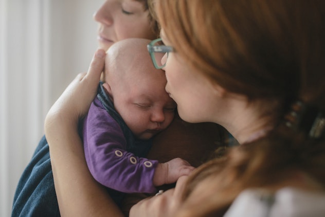 Parents snuggling newborn baby close, in a story about emo baby names.