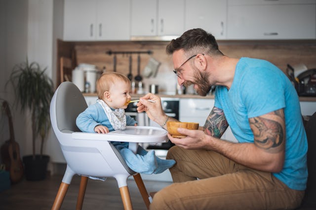Father feeding his baby son and he is enjoying the delicious vegetable puree.