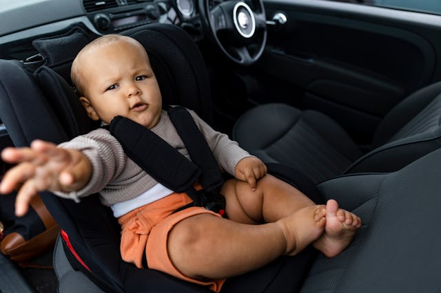 Baby sitting in a car seat inside of a car in the North East of England. He is looking at the camera...