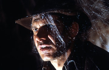 Harrison Ford walks through cobwebs in a scene from the film 'Indiana Jones And The Last Crusade', 1...