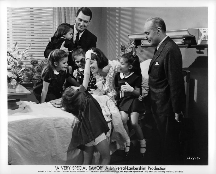 Rock Hudson visits Leslie Caron in the maternity ward with all her daughters on the bed with her as ...