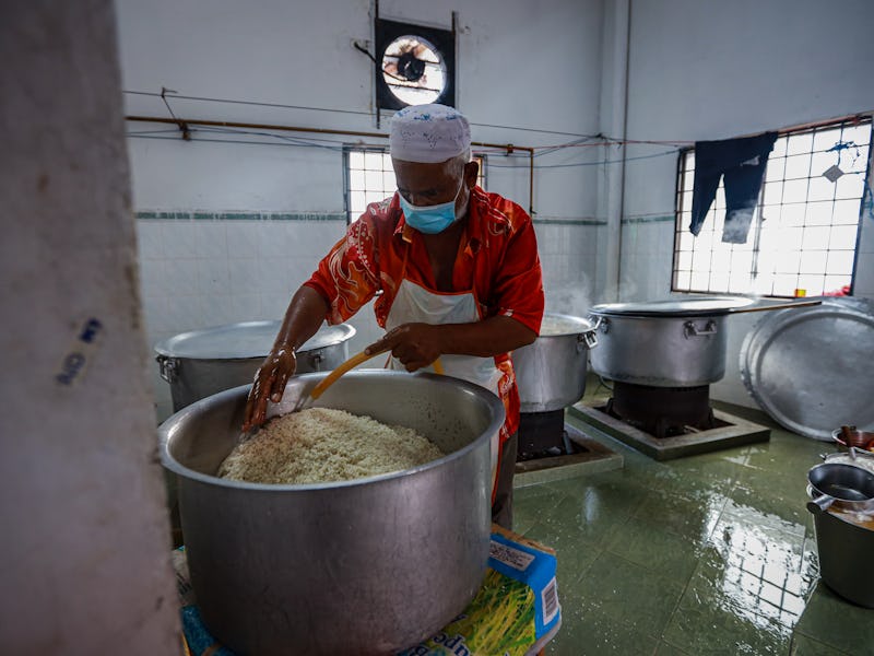KUALA LUMPUR, MALAYSIA - MAY 07: A Muslim man washes a pot of rice as he prepares 'Bubur Lambuk' kno...