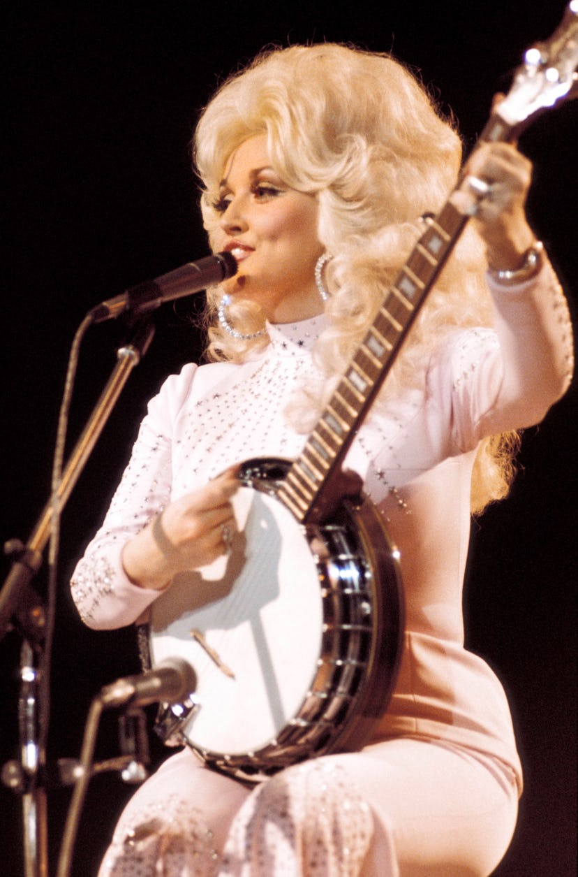 Dolly PARTON wears a sparkly pink pantsuit while performing at the UK Country Music Festival.