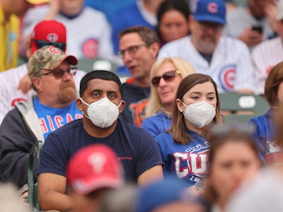 CHICAGO, ILLINOIS - JUNE 27: Fans wear masks during the game between the Chicago Cubs and the Philad...