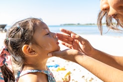 Mother putting sunscreen on her daughter's face, best SPF for kids that hate sunscreen