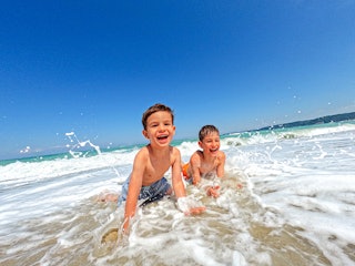 Two young boys play in the ocean without their parents. Recently, two "lighthouse parents" were unde...
