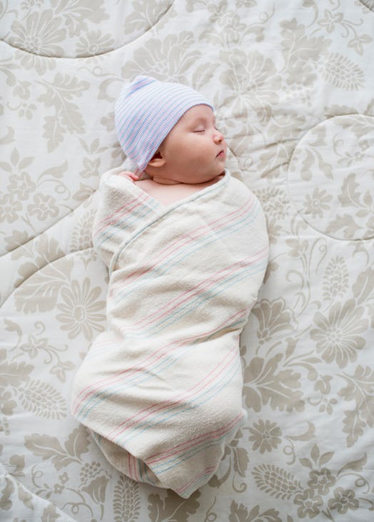 asian baby swaddled sleeping on bed in article about asian babies and sids