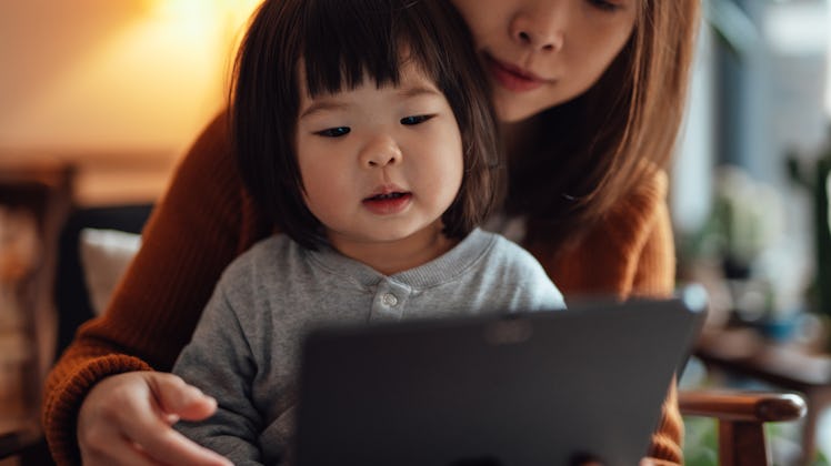Closeup of mother and her toddler daughter talking with doctor on video call with digital tablet.