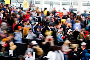 Travelers wait in line before passing through a security checkpoint at Denver International Airport ...