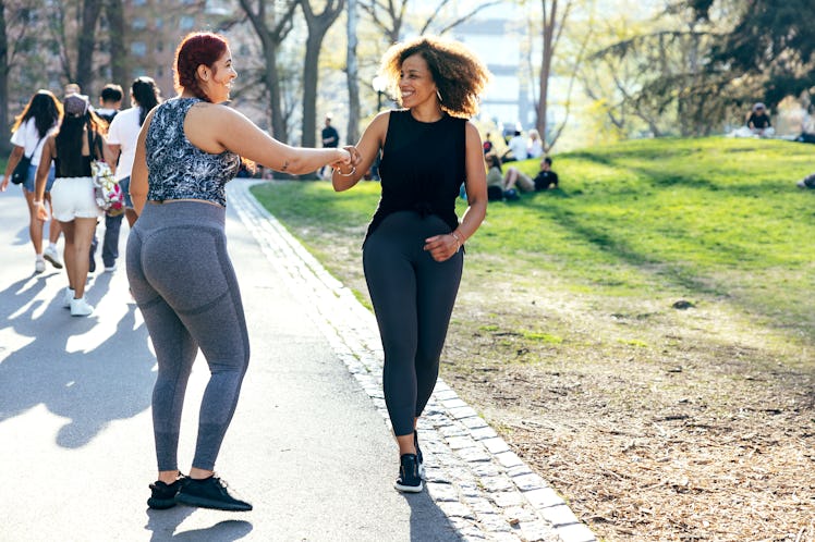 Two female friends enjoying great moments sharing a run in the park.