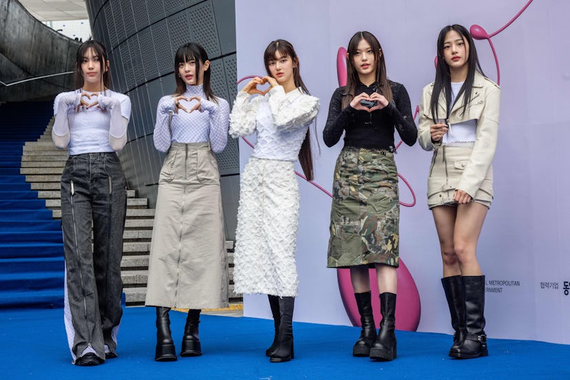 Members of South Korean K-pop group NewJeans pose on the blue carpet at Seoul Fashion Week at Dongda...