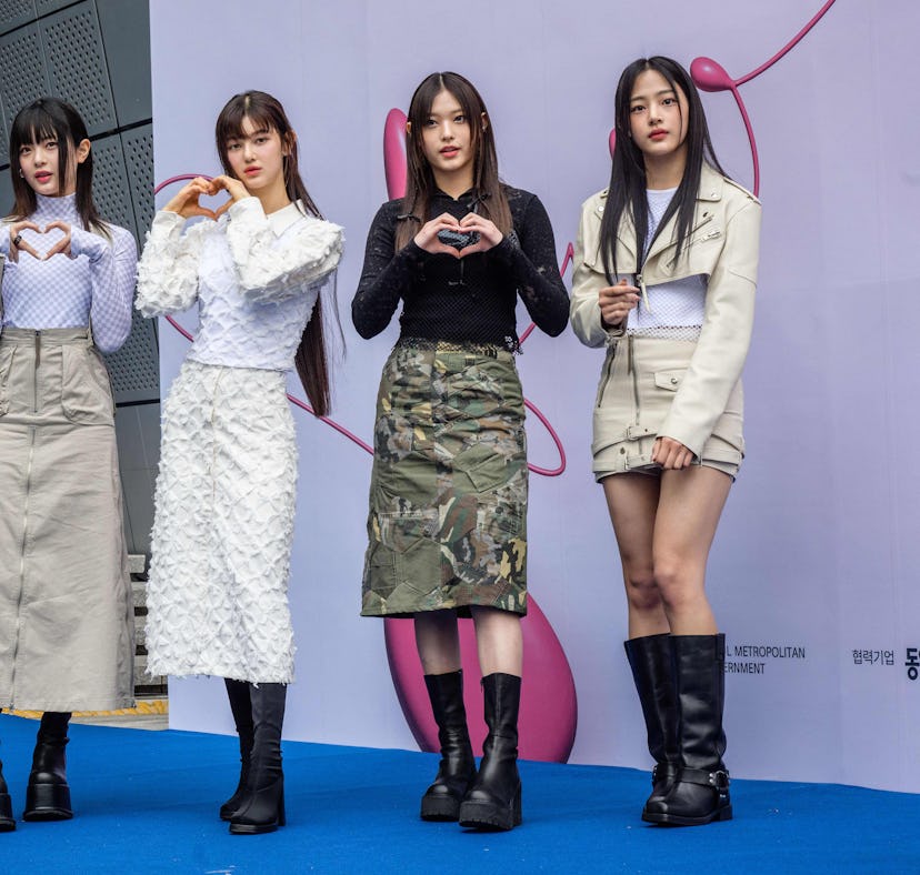 Members of South Korean K-pop group NewJeans pose on the blue carpet at Seoul Fashion Week at Dongda...