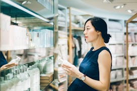 Pregnant woman shops for pregnancy safe skin care in a high end store.