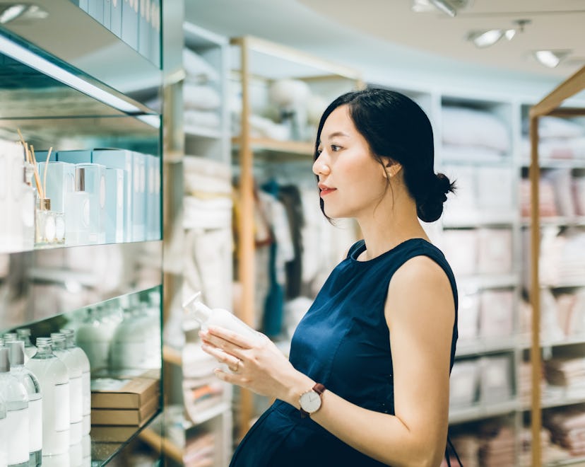 Pregnant woman shops for pregnancy safe skin care in a high end store.