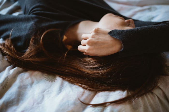 A woman lying/sleeping on her back, wondering does ovulation make you sleepy