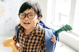 Smiling boy with backpack and favourite guitar in article about photo captions for kindergarten
