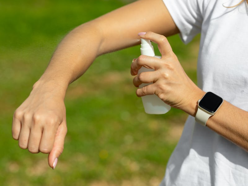 Woman spraying mosquito insect repellen
