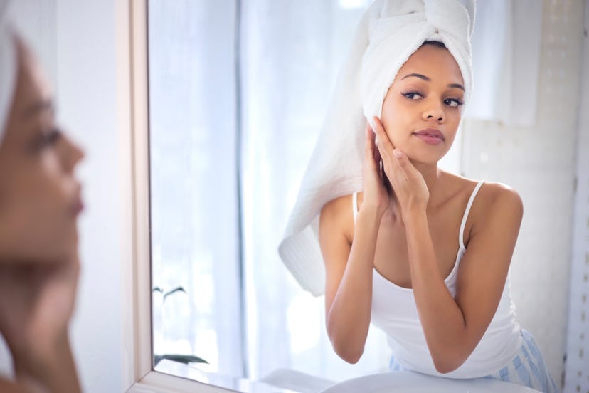 Skincare, beauty and face of black woman in mirror for cleaning, grooming and facial treatment at ho...