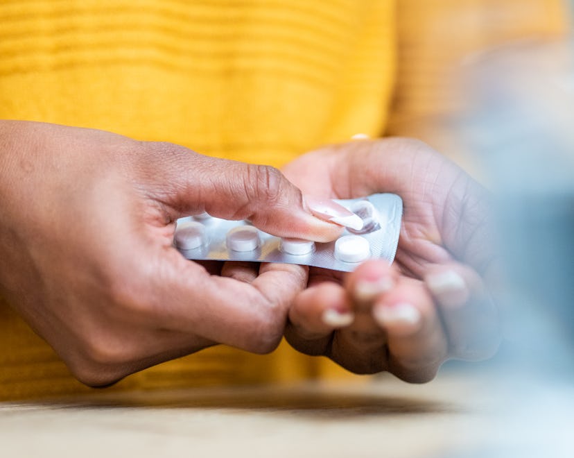 woman opening medicine in an article about otc medications and fertility