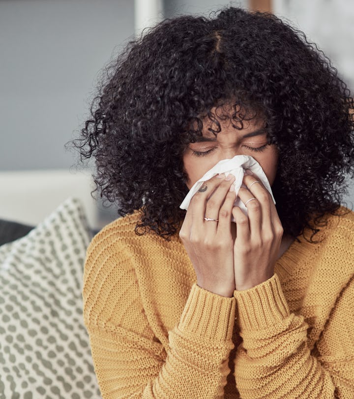 Shot of a young woman blowing her nose with a tissue at home, is a cold a sign of pregnancy?