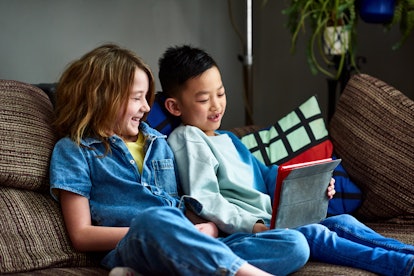 photo of two happy kids playing a game on a sofa in article about back to school tips for parents