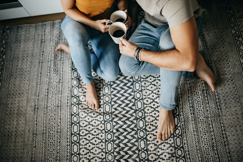 Couple in the kitchen, sitting on the floor and drinking coffee, in a story answering the question, ...