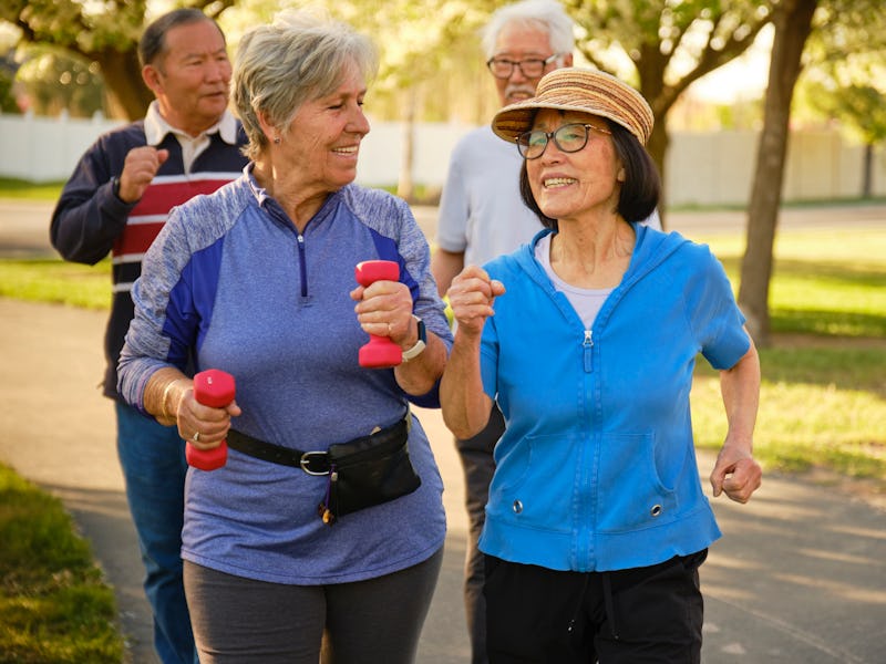 A group of senior aged people power walking in a park.