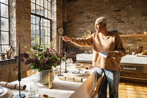 Black female in her 30s putting finishing touches to her table set for Christmas lunch