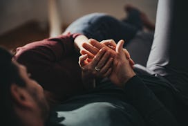Unrecognizable couple intertwines their hands in a story answering the question, can you have sex du...