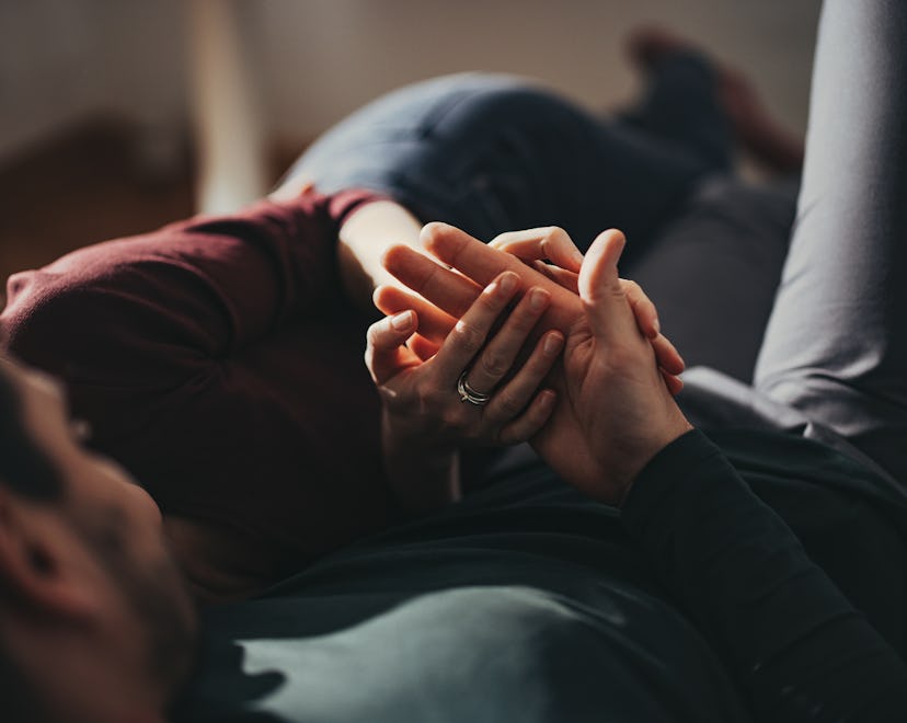 Unrecognizable couple intertwines their hands in a story answering the question, can you have sex du...