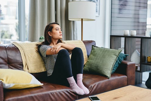 Shot of a young woman sitting on the couch at home