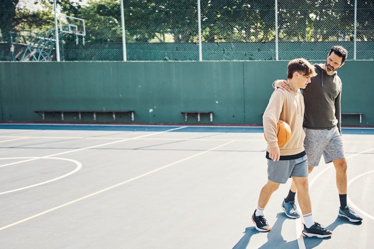 Father and son walking after playing a game of basketball. Maybe they're talking about gun safety ed...
