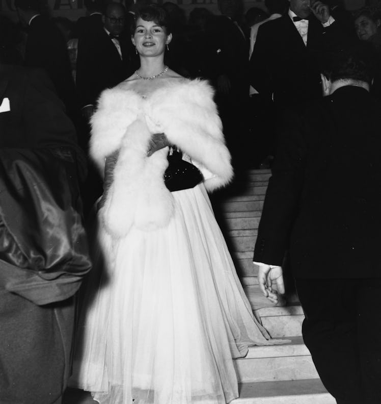 Actress Brigitte Bardot wearing a ball gown and fur stole 
