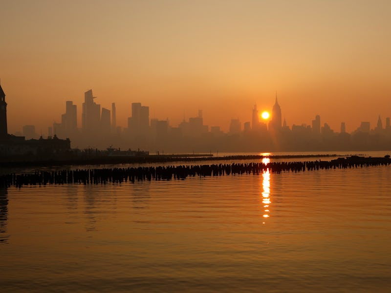 JERSEY CITY, NJ - JULY 5: Haze shrouds the skyline of midtown Manhattan as the sun rises behind the ...