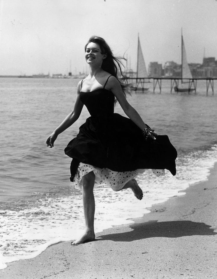 Running barefoot on the sands at Cannes, French film star, Brigitte Bardot 