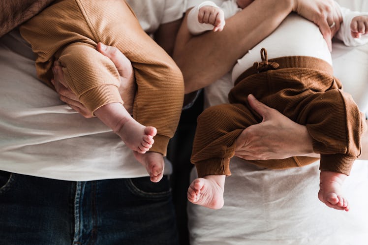 Parents holding young babies, close-up.