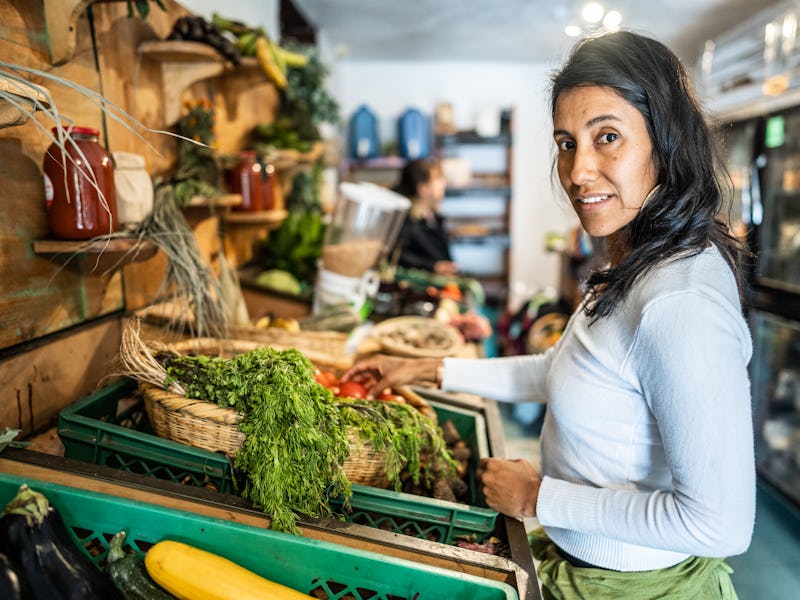 Portrait of mid adult woman buying vegetables at market