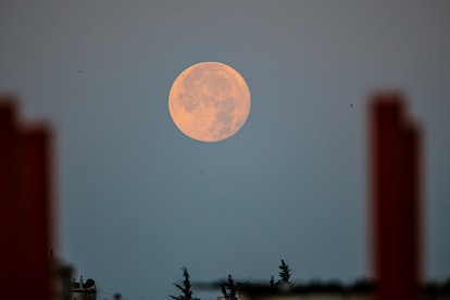 The giant moon during its rising and setting in the village of Deir Ballout, northwest of Syria, on ...